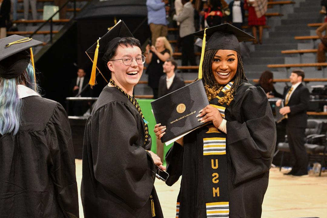 毕业典礼上，学生们拿着毕业证书微笑着. 